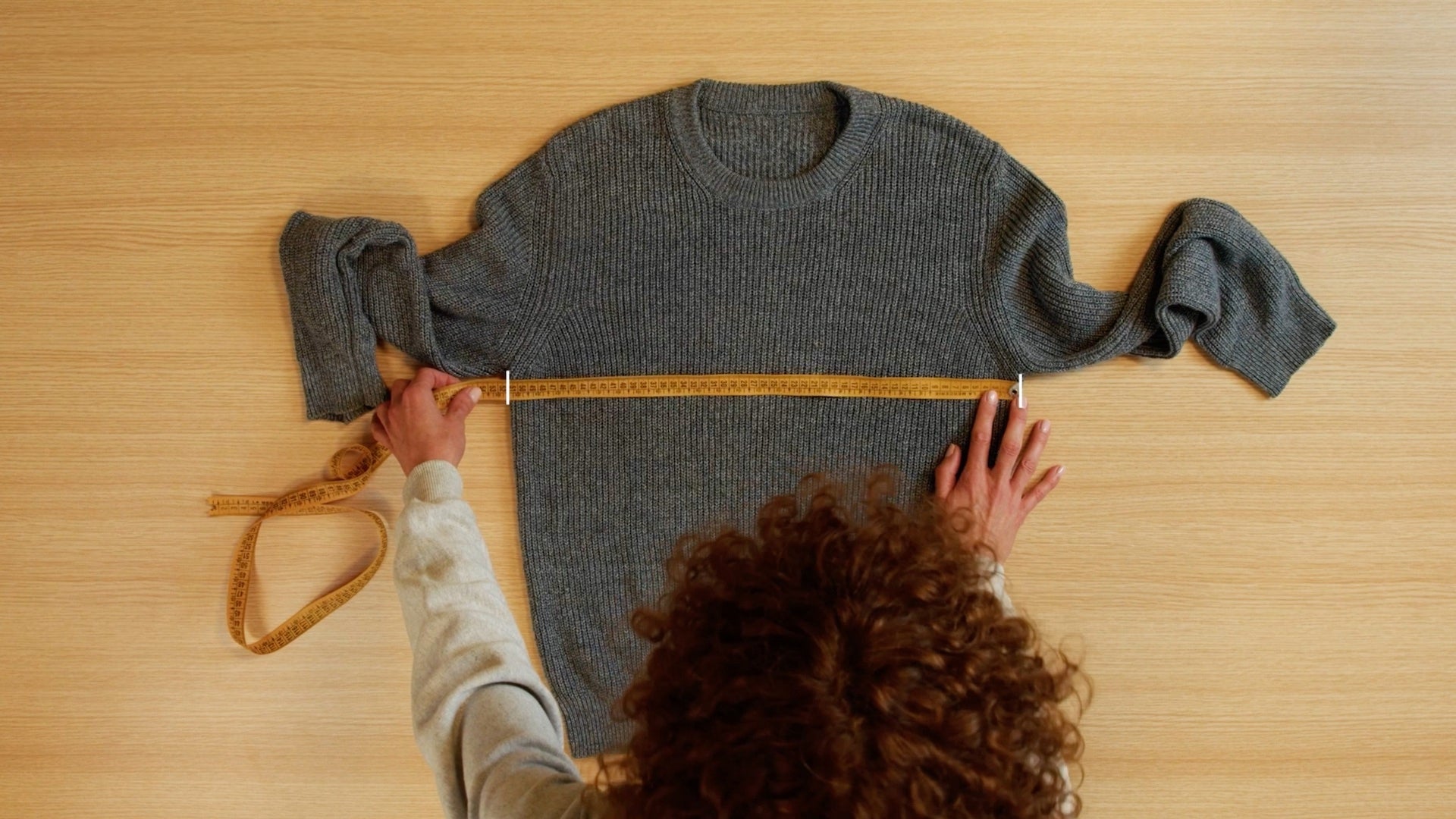 Chest-width measurement on a laid-flat knit.